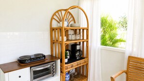 A kitchenette with a stove, oven, and a coffee maker on a shelf. - An Affordable Alternative to Expensive Accommodations in Poipu (Poipu)