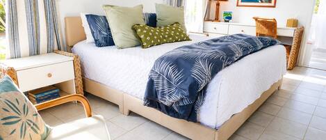 A bedroom with a bed, bedside tables, a chair, and a nightstand.
