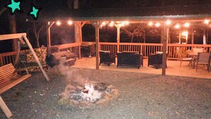 An outdoor patio area with a fire pit, seating, and string lights. - Once a Part of the Beloved Shady Oak Lodge - Cabin 1 - 4 beds with Boat Ramp (Many)