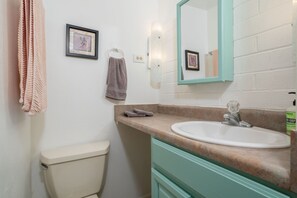 Een bad/douchecombinatie, een haardroger, handdoeken, zeep