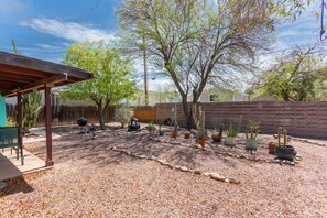 A patio area with a pergola, a barbecue grill, and various potted cacti. - DESERT OASIS FOR RELAXING (Tucson)