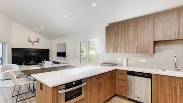 A modern kitchen with wooden cabinets, a large island, and built-in appliances.