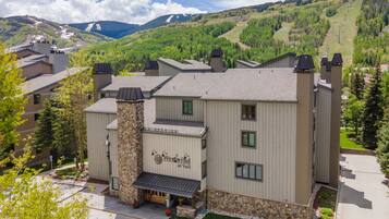 A hotel with a stone facade, multiple windows, and a sign reading "WestWind at Vail."