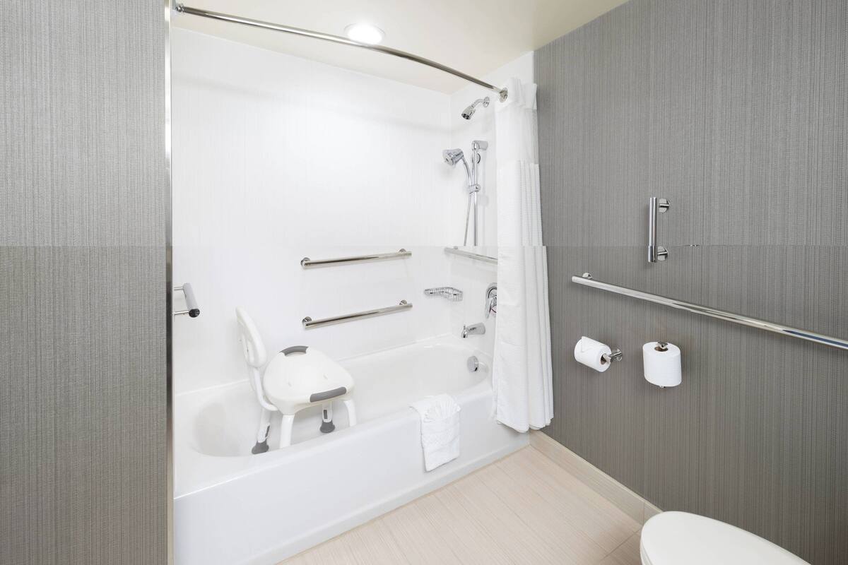 A modern bathroom with a bathtub, a toilet, and a shower area.