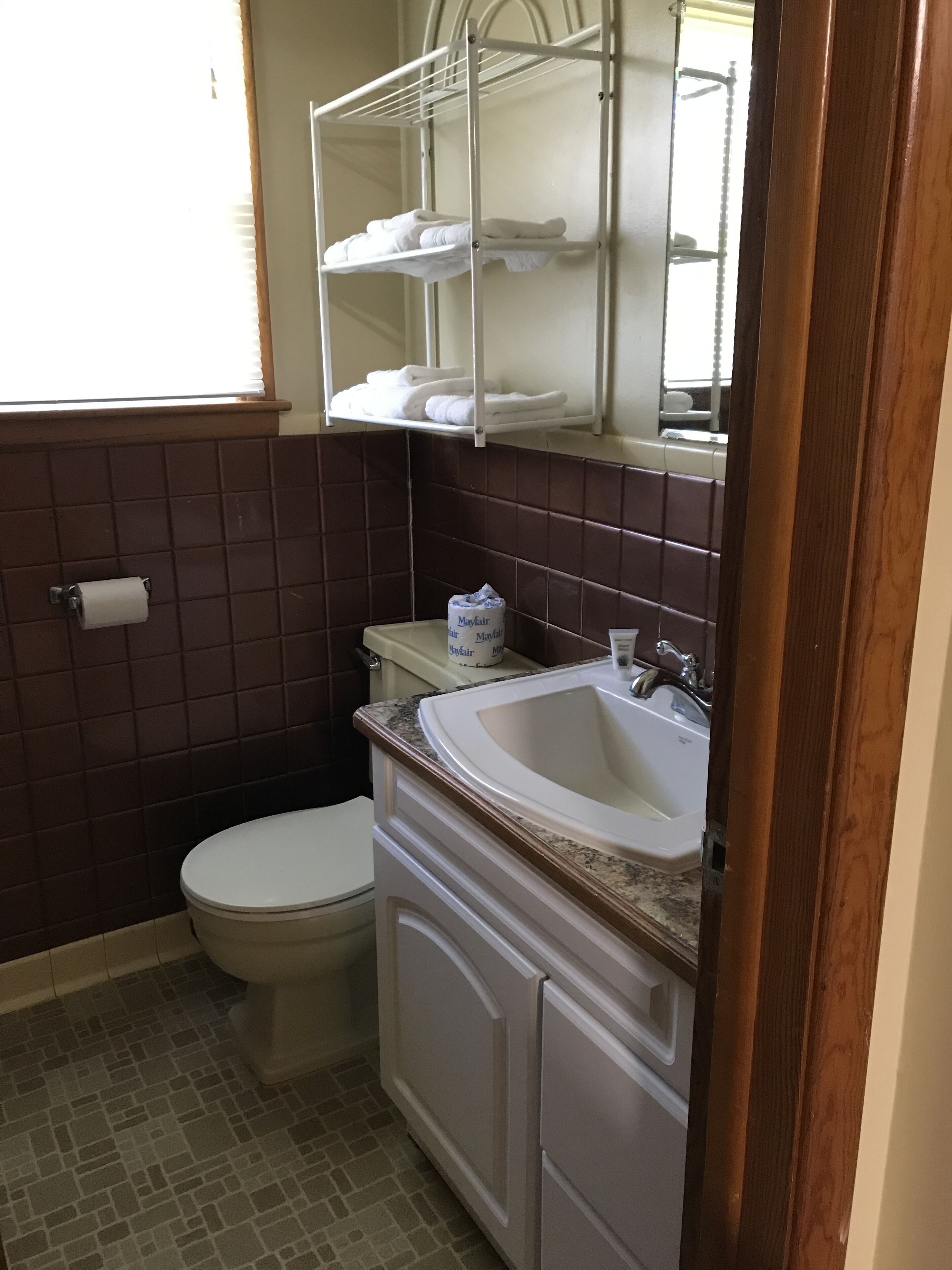 A bathroom with a toilet, sink, and towel rack.