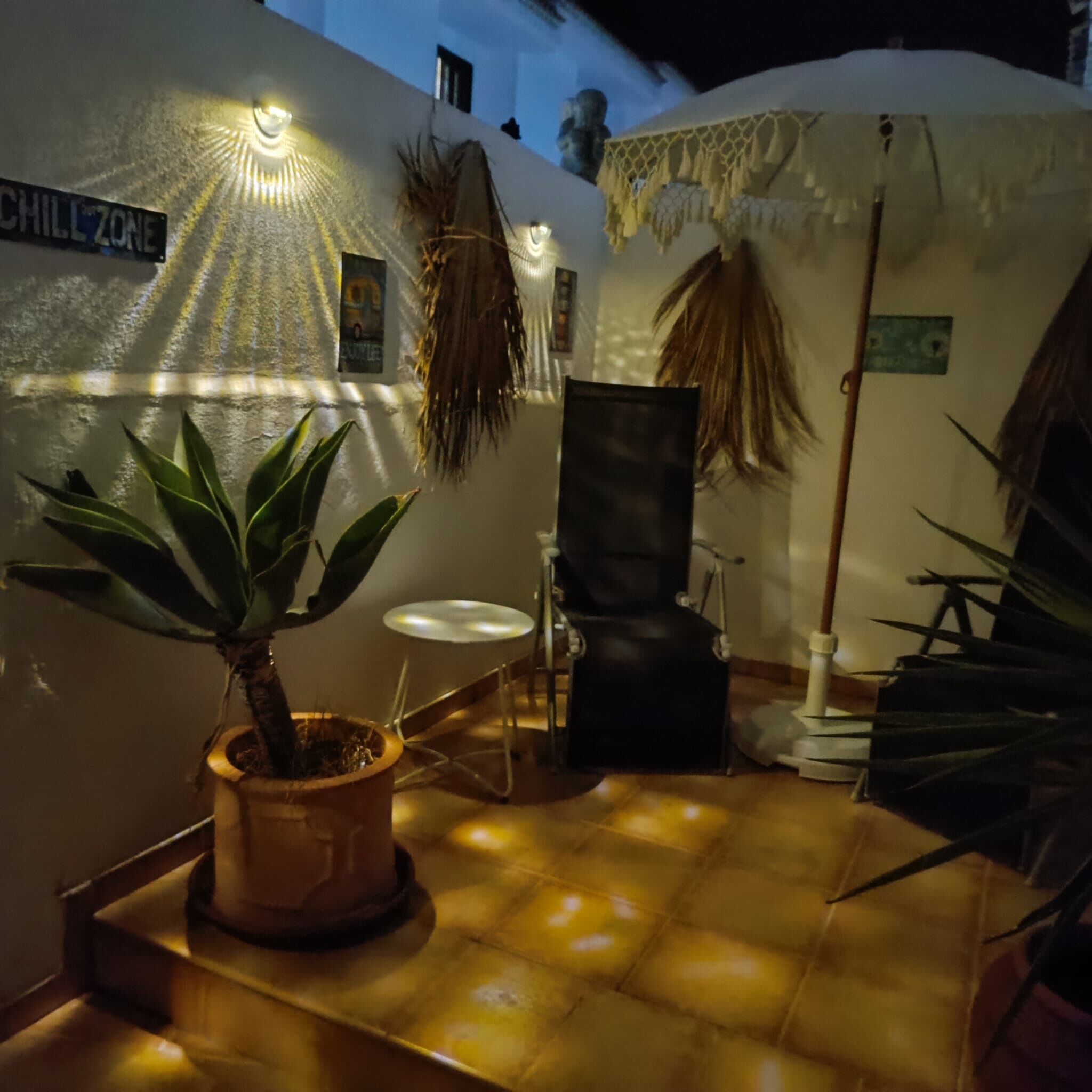 A cozy indoor space with a potted plant, a chair, and a sign reading "CHILL ZONE".