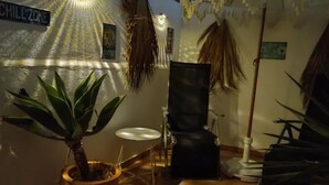 Un espacio interior acogedor con una planta en maceta, una silla y un cartel que dice 'CHILL ZONE'.