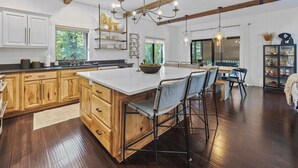 Una cocina amplia con armarios de madera, una isla grande y taburetes de bar.
