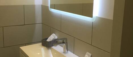 A bathroom with a white sink, a mirror, and a towel rack.