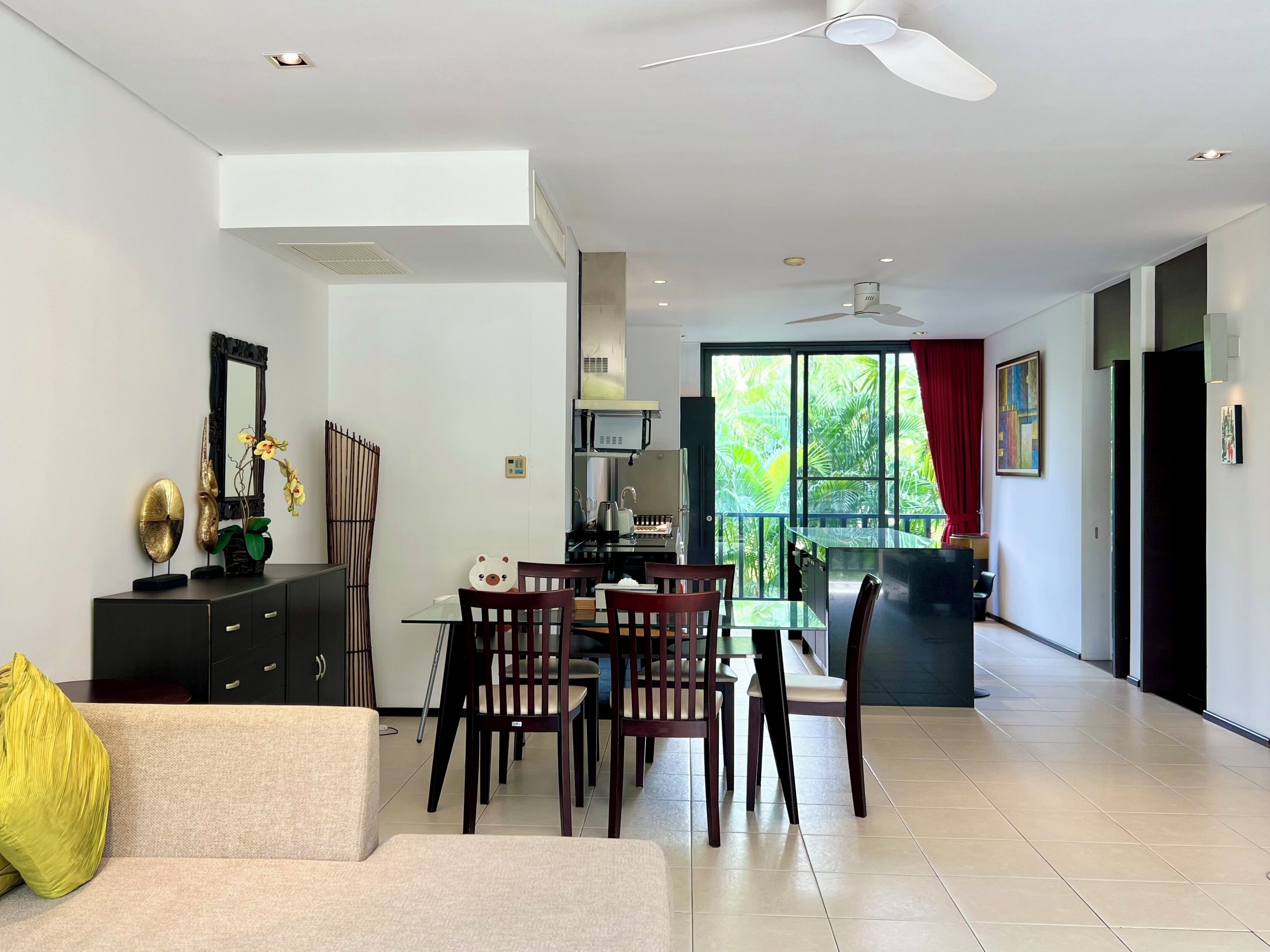 Una sala de estar moderna con comedor, sofá, mesa de centro y televisor.