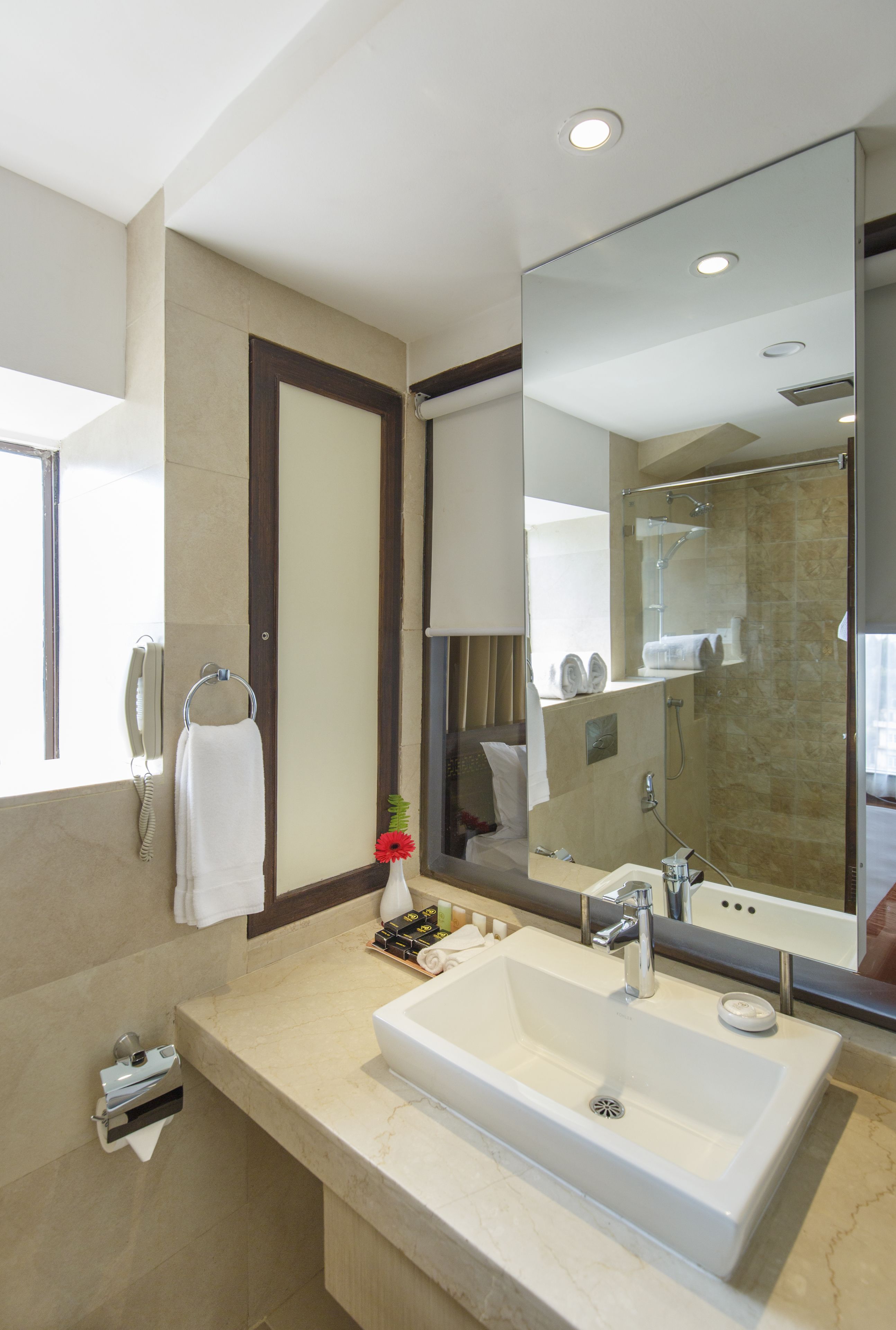 A modern bathroom with a large mirror, a sink, and a shower.