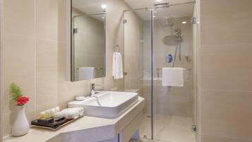 Une salle de bain moderne avec une douche à parois de verre, un grand lavabo et un miroir au-dessus.