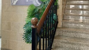 Eine Treppe mit Handlauf und einem an der Wand befestigten Poster eines roten Doppeldeckers.