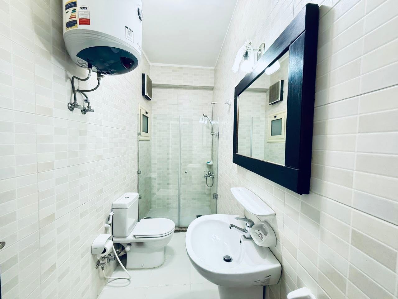 A bathroom with a toilet, sink, and shower.
