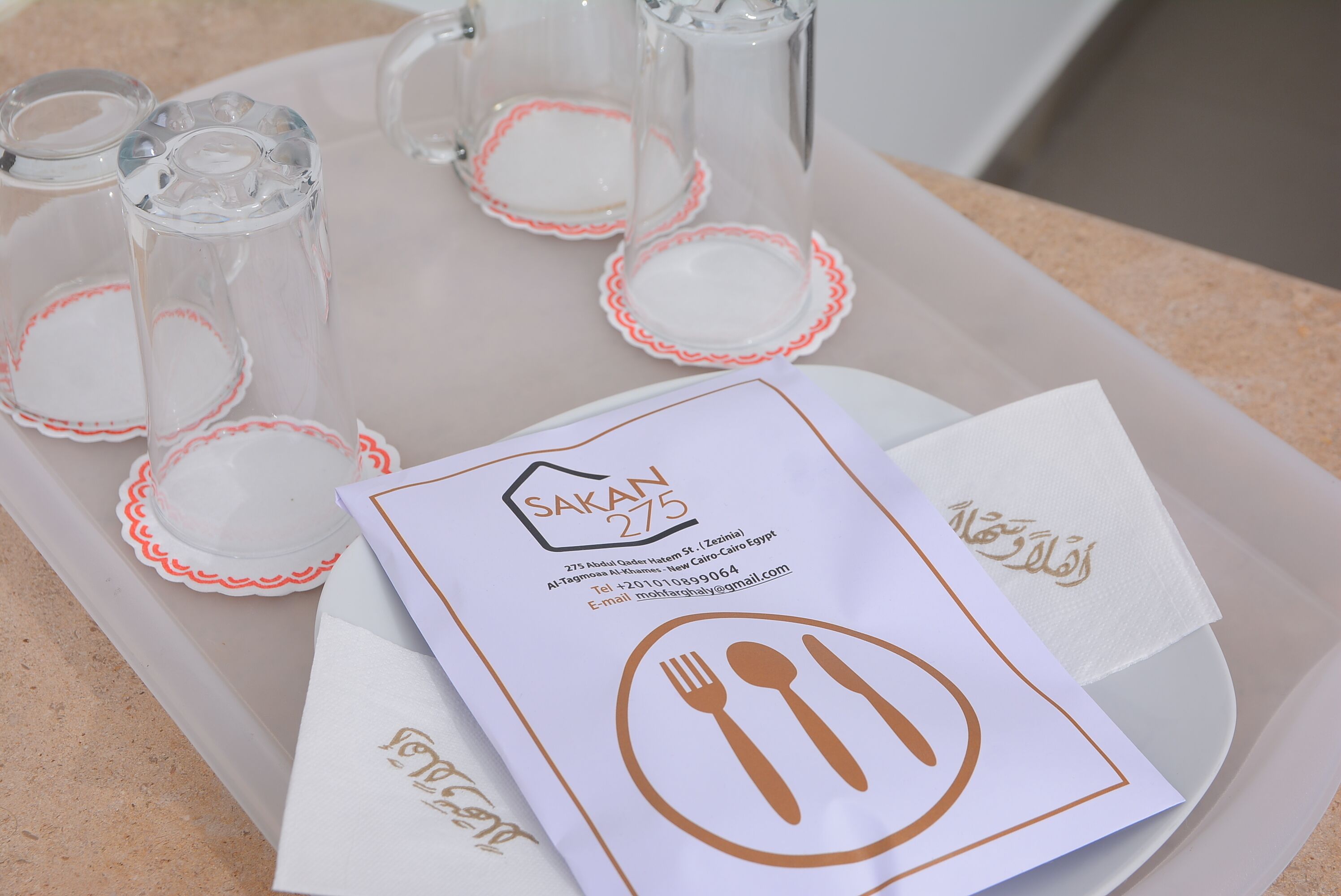 A tray with shot glasses, a menu, and napkins.