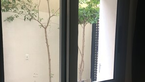 Ein Fenster mit Blick auf einen Baum und einen Zaun.