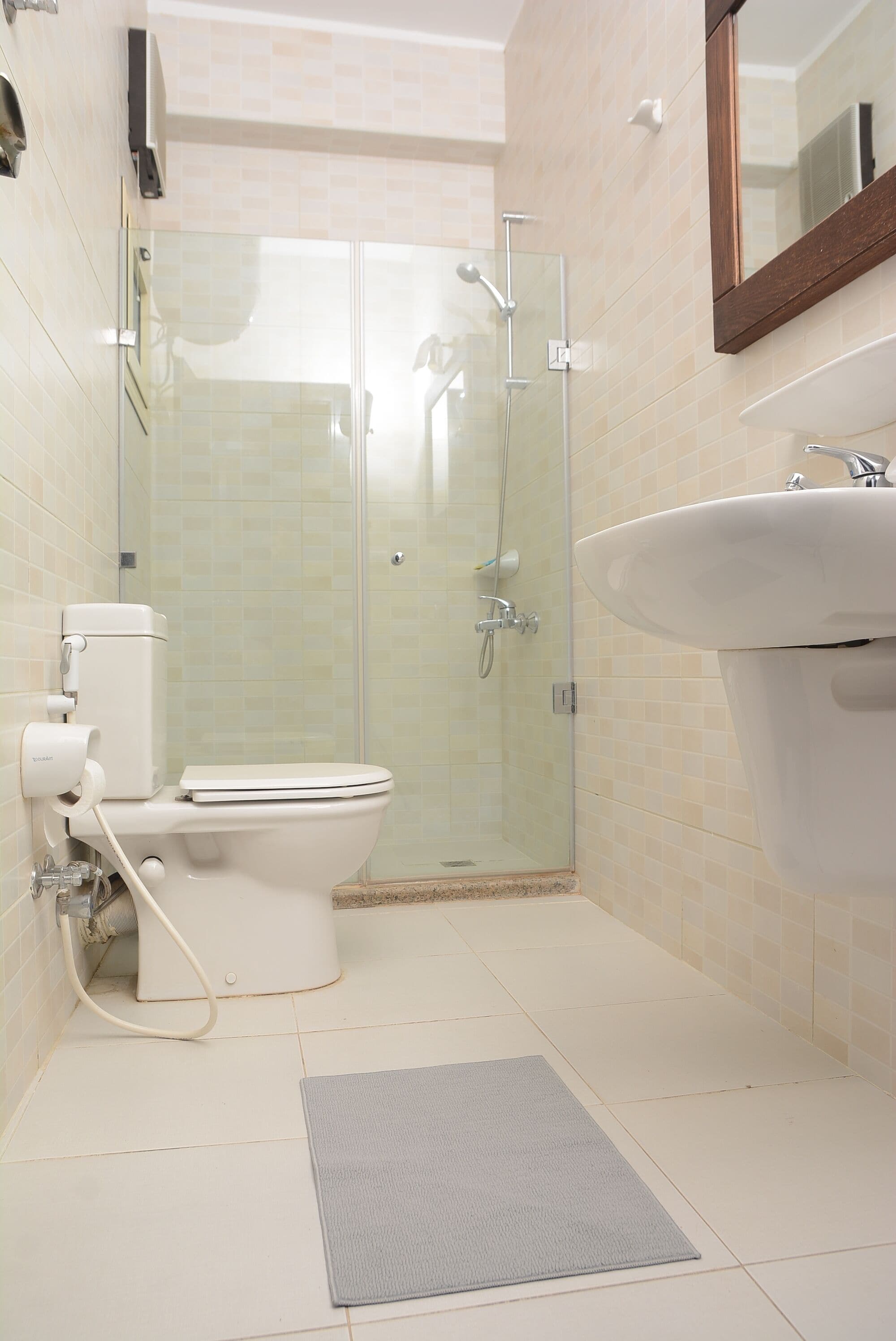 A bathroom with a toilet, a glass-enclosed shower, and a sink.