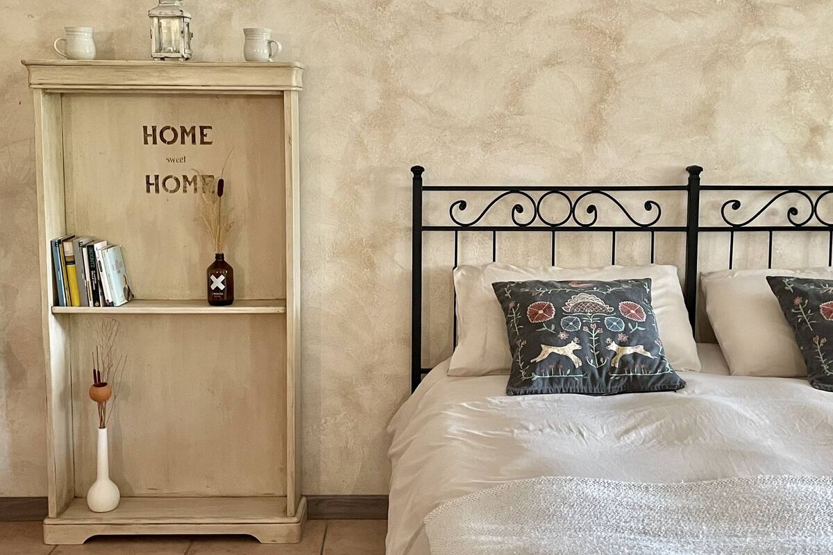 A bedroom with a bed, a nightstand, and a cabinet.