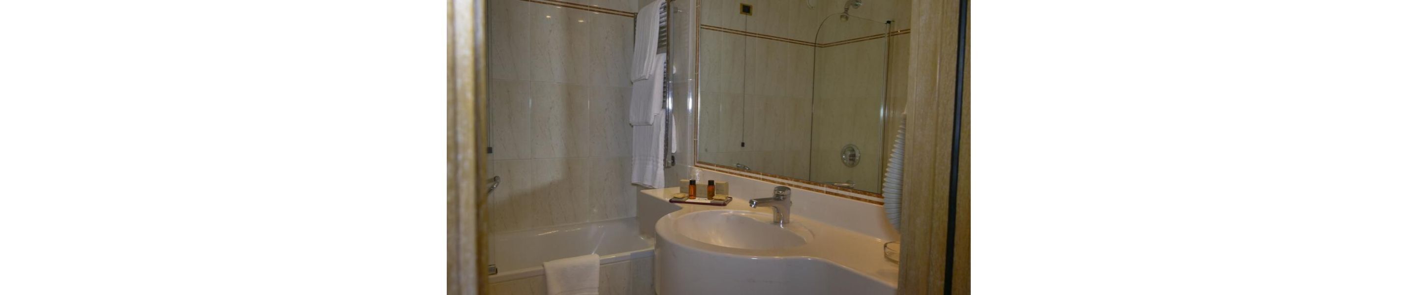 A bathroom with a bathtub, a sink, and a mirror.