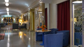 Eine Hotelhalle mit einer langen Korridor, Sitzbereichen und einer Rezeption.