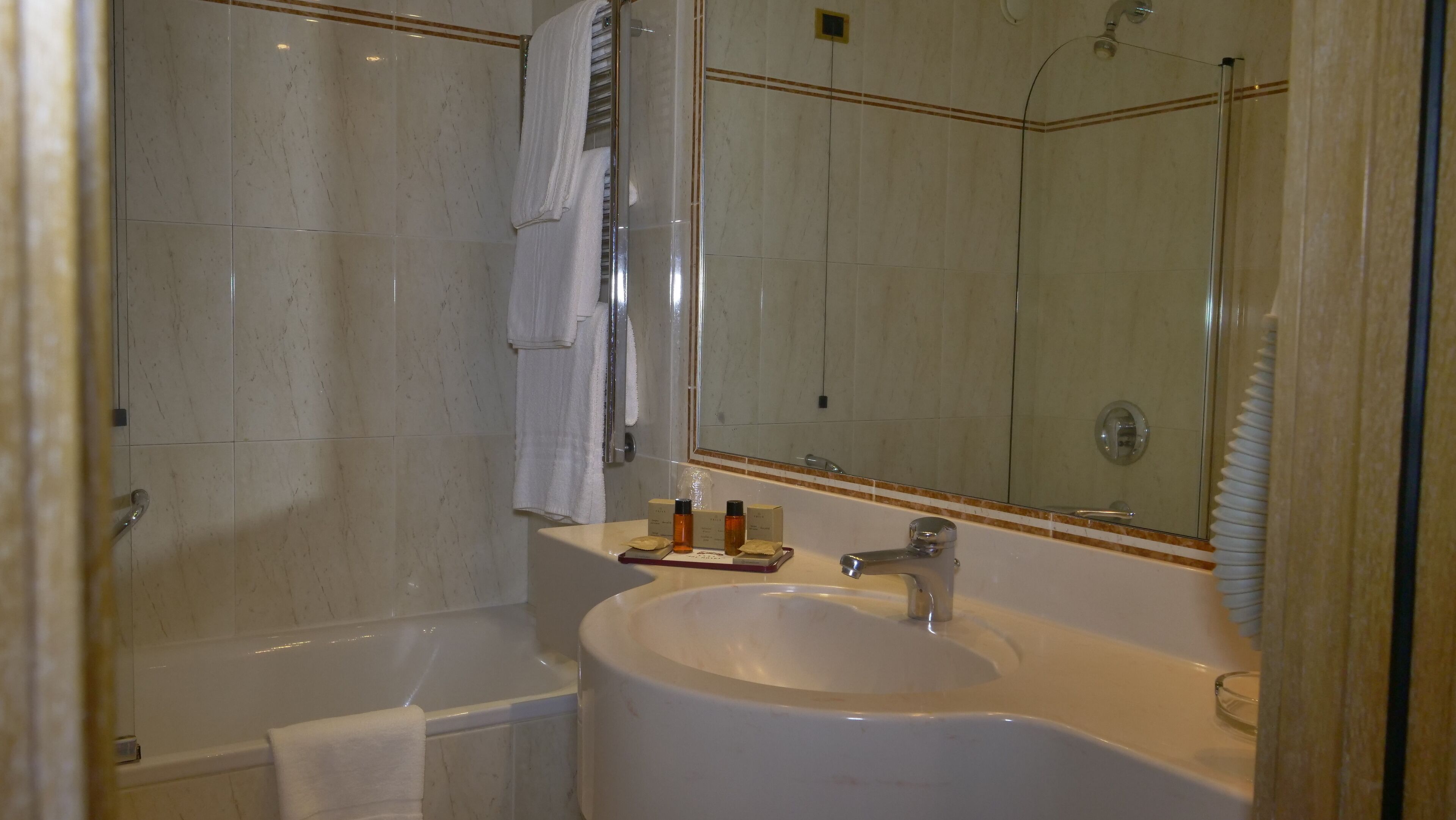 A bathroom with a bathtub, a sink, and a mirror.