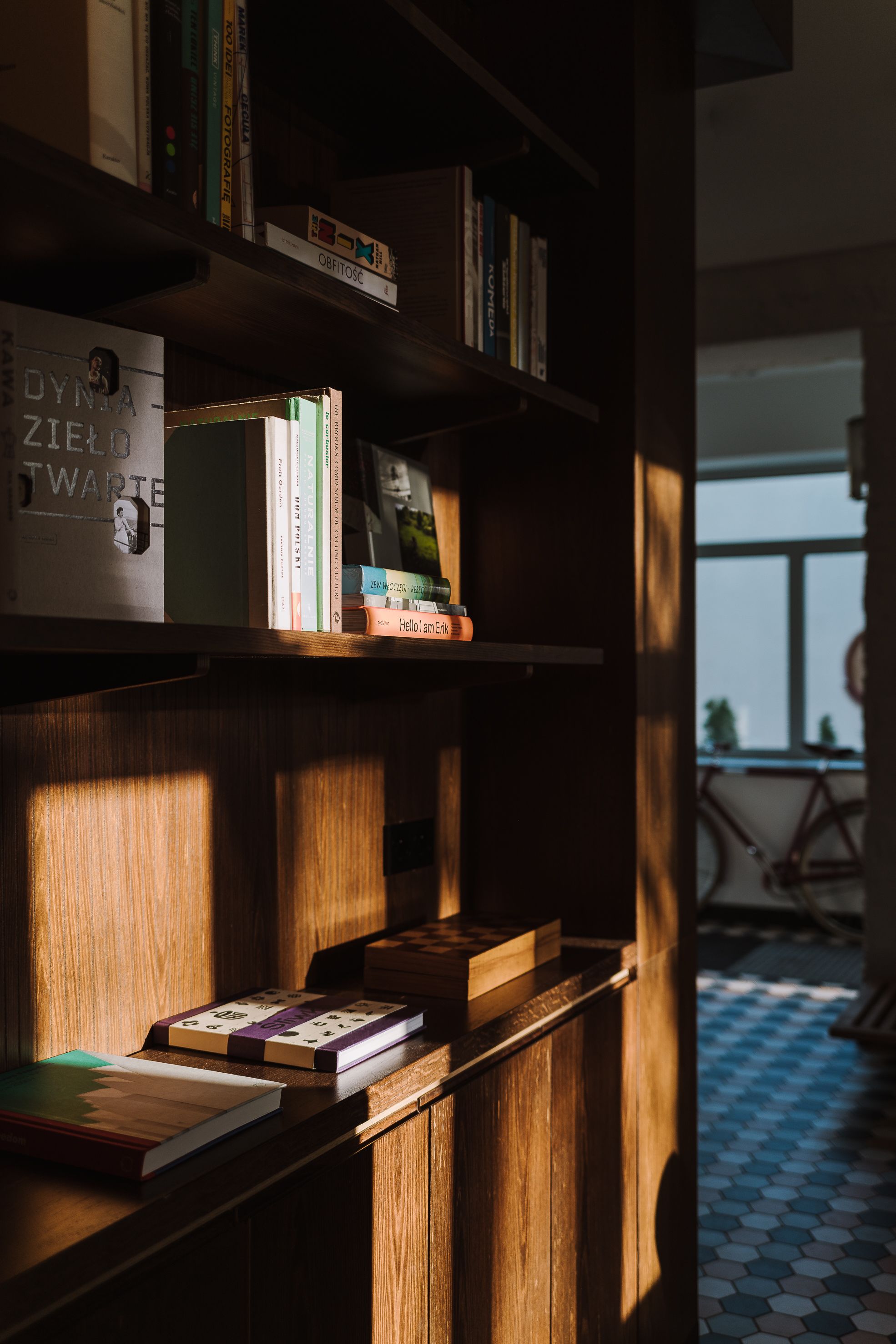 Uma estante com livros e um quadro emoldurado.