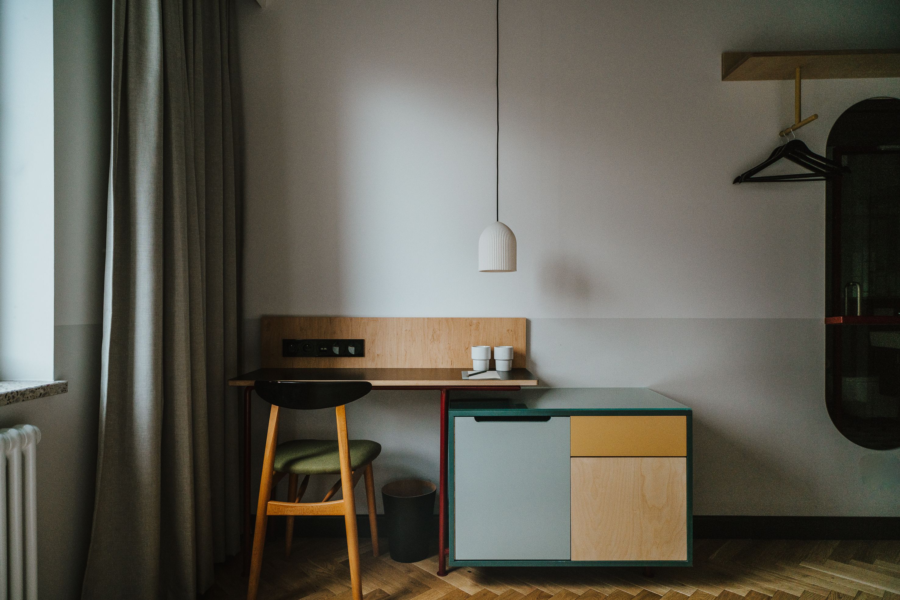 A compact kitchenette with a wooden countertop, a small cabinet, and a hanging light fixture.