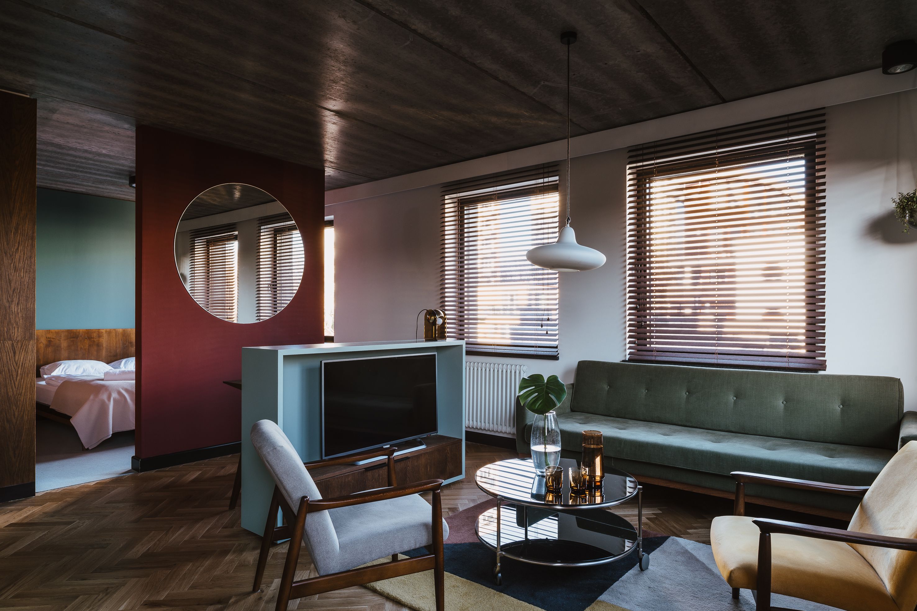 A modern living room with a sofa, armchairs, a coffee table, and a TV.