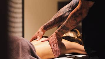 Experience a soothing massage on a comfortable table with a padded headrest and cushion.