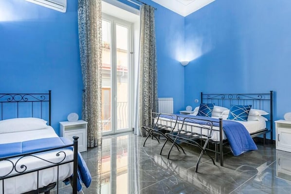 A bedroom with two beds, a large window, and a view of the outside. - B&B Palazzo Majorana (Naples)