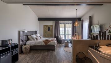 Un dormitorio moderno con una cama grande, mesitas de noche, un escritorio y un baño con lavabo y espejo.