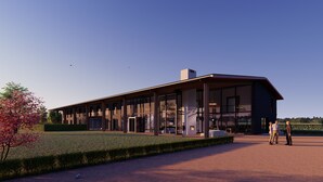 Un edificio moderno con amplios ventanales y un espacio exterior cubierto.