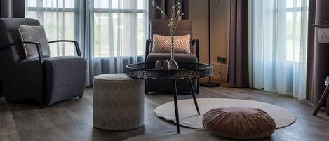 A modern living room with a sofa, ottoman, and round coffee table.
