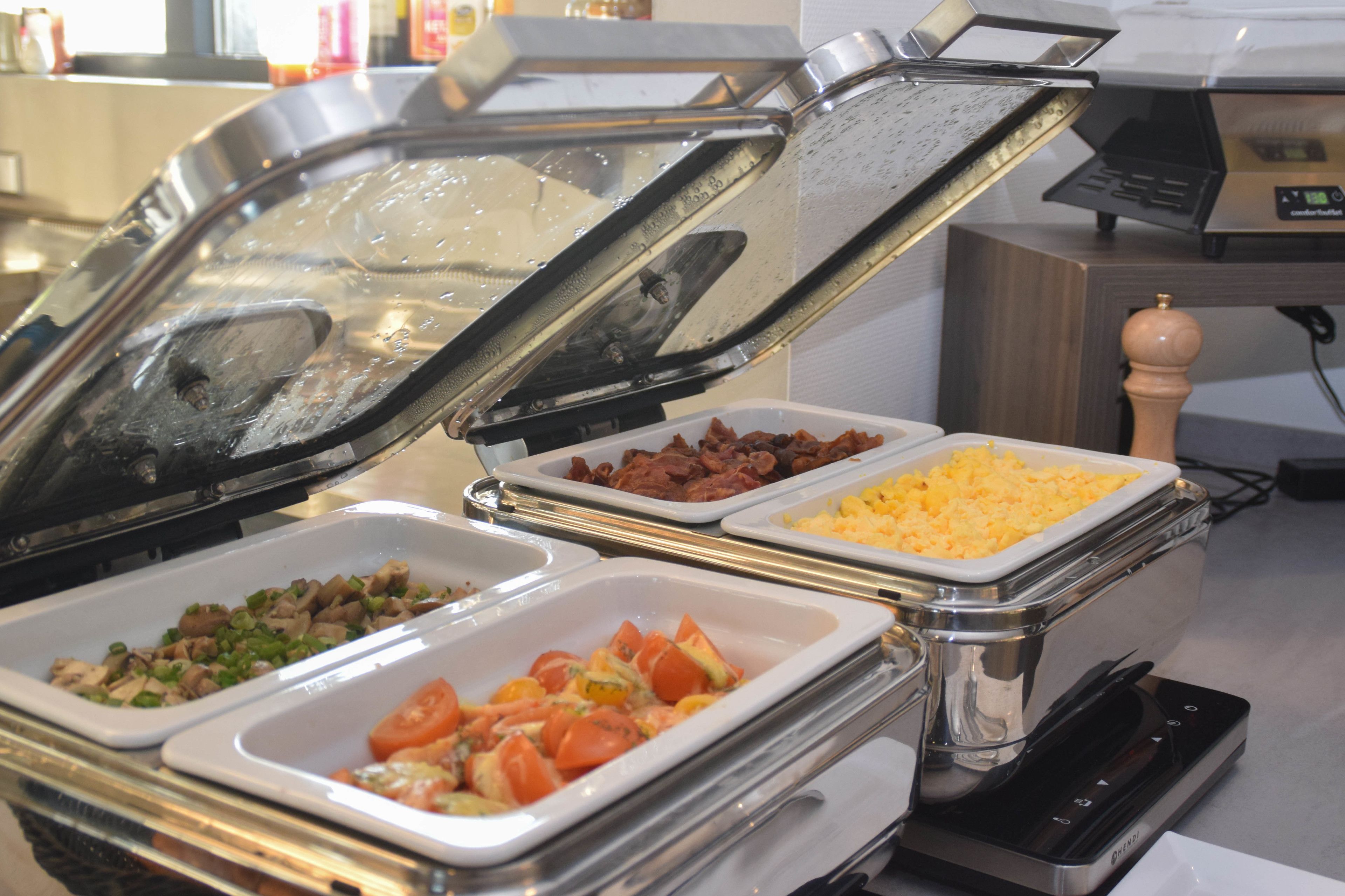 A buffet with various food items including meats, cheeses, and vegetables.