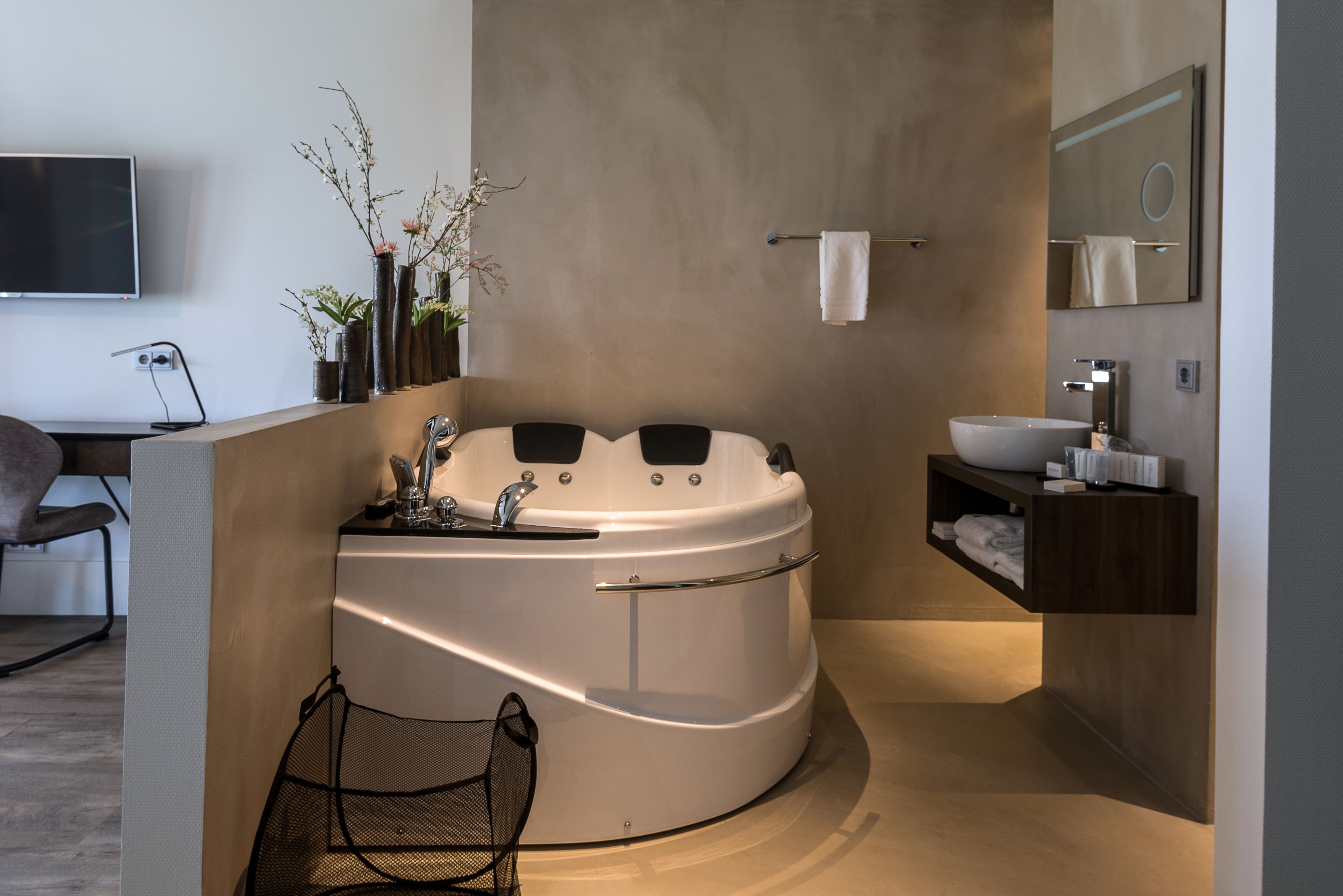 Un bagno moderno con una vasca da bagno freestanding, un mobile vanità con lavabo e uno specchio.