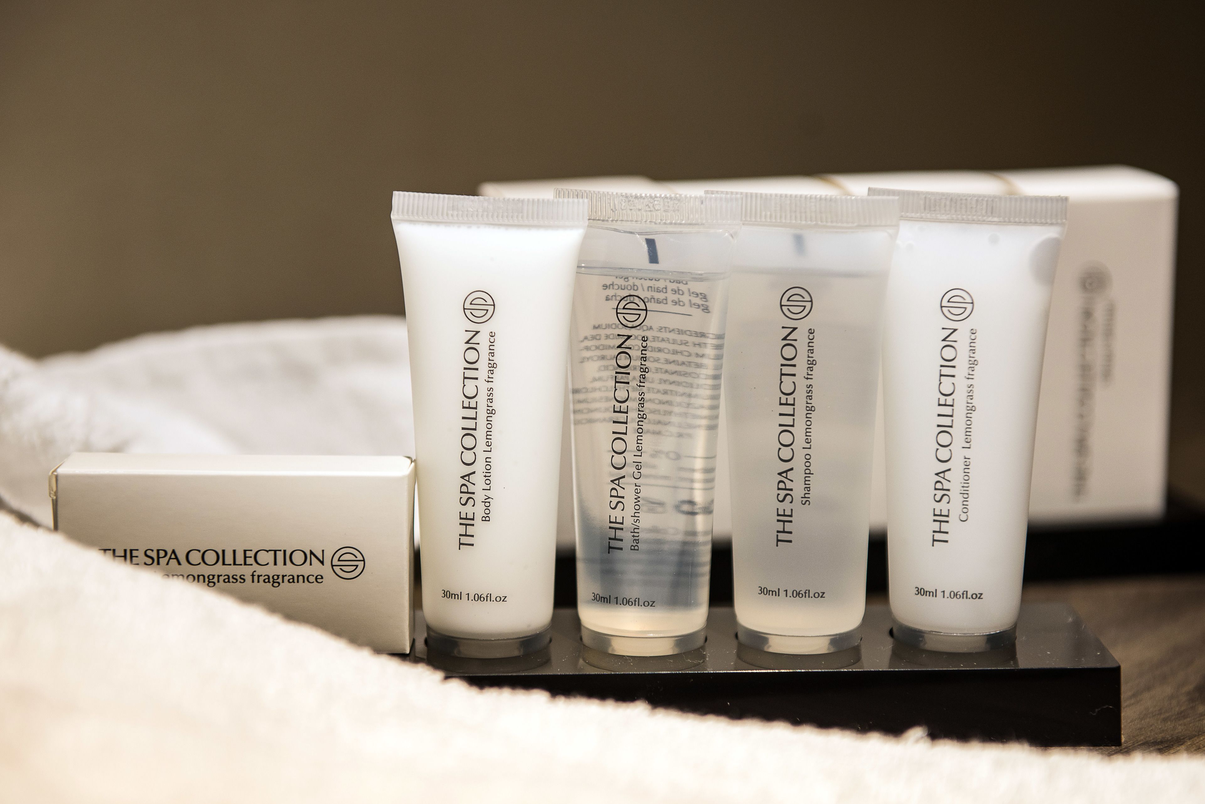 Presentación de productos de The Spa Collection, incluyendo loción corporal, gel de ducha, champú y acondicionador.