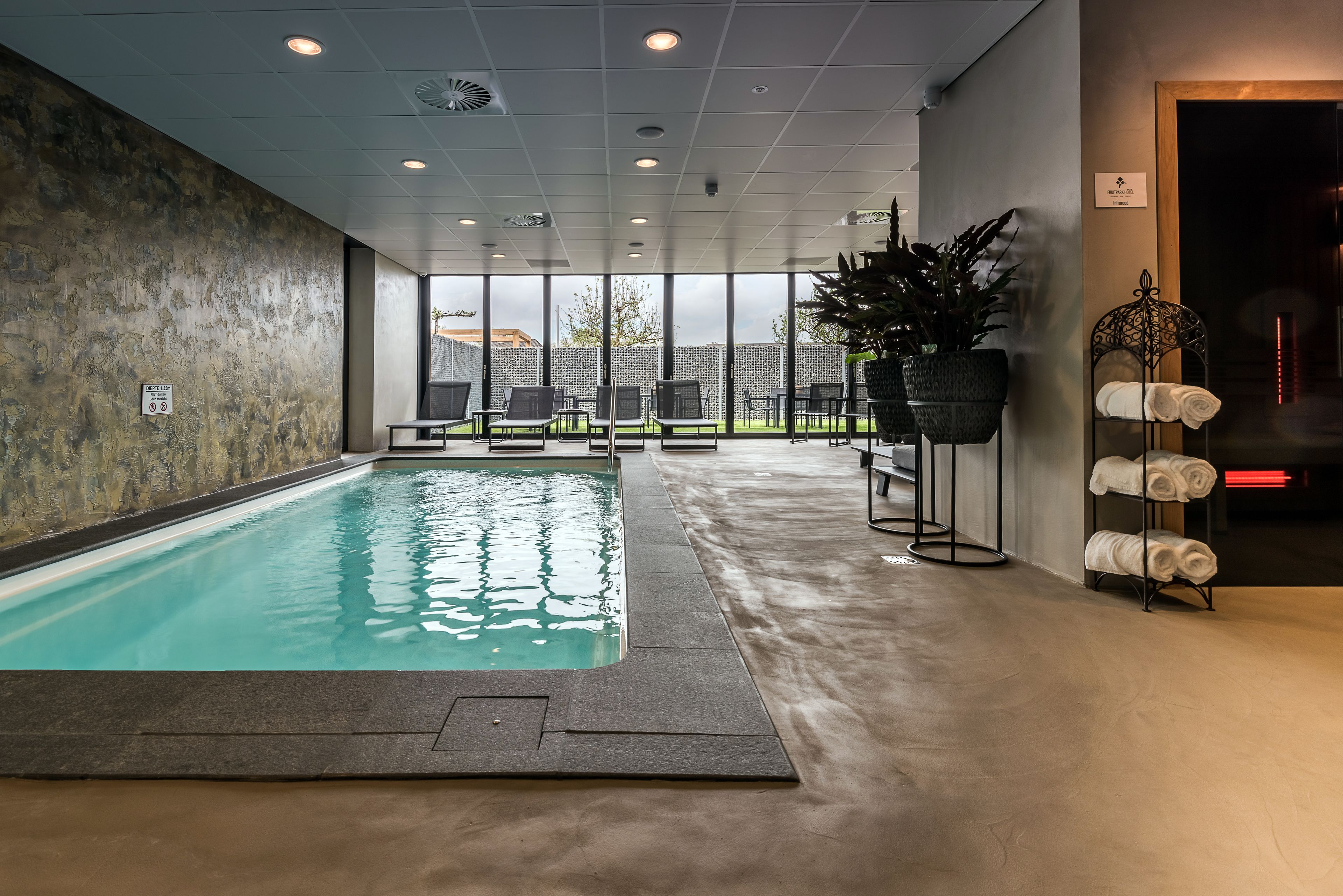 Una piscina techada, sillones reclinables de piscina