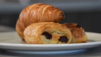 A plate with two pastries, one whole and one cut in half, revealing a dark filling.