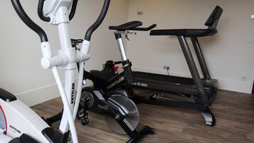 Ett hemmagym med en motionscykel, en crosstrainer och ett löpband.
