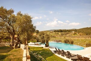 Una piscina al aire libre de temporada, sombrillas