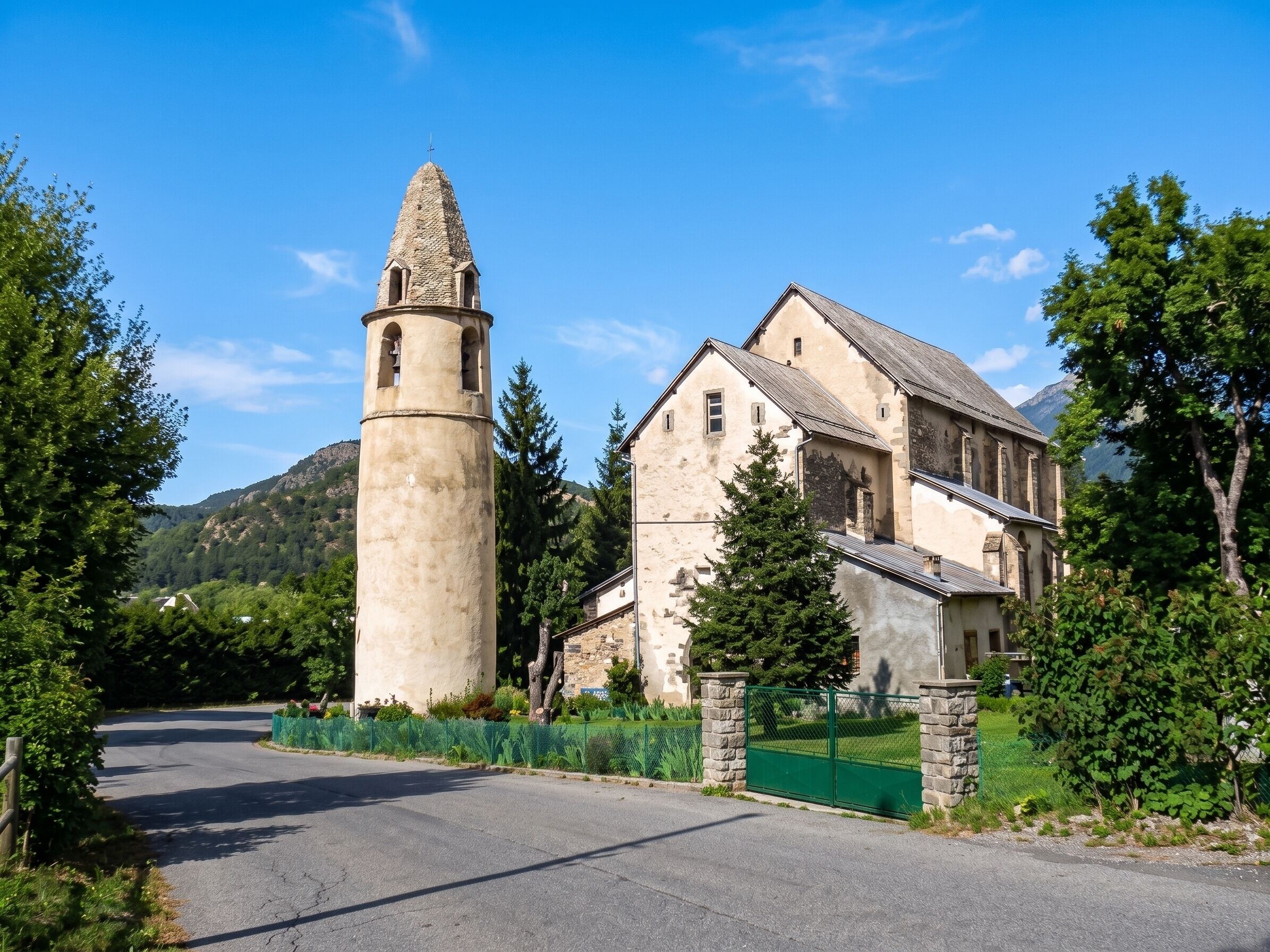 Un bâtiment historique doté d’une tour imposante, d’une entrée fermée par un portail et d’une route menant à celui-ci.