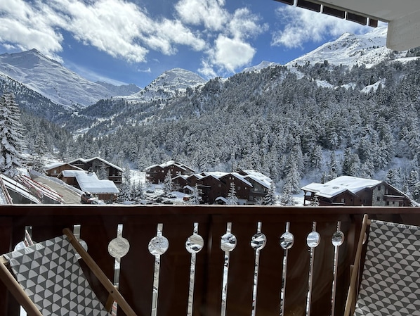 Vista de la montaña con árboles nevados y edificios.