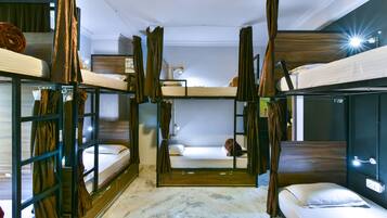 A room with bunk beds, a small table, and a lamp.