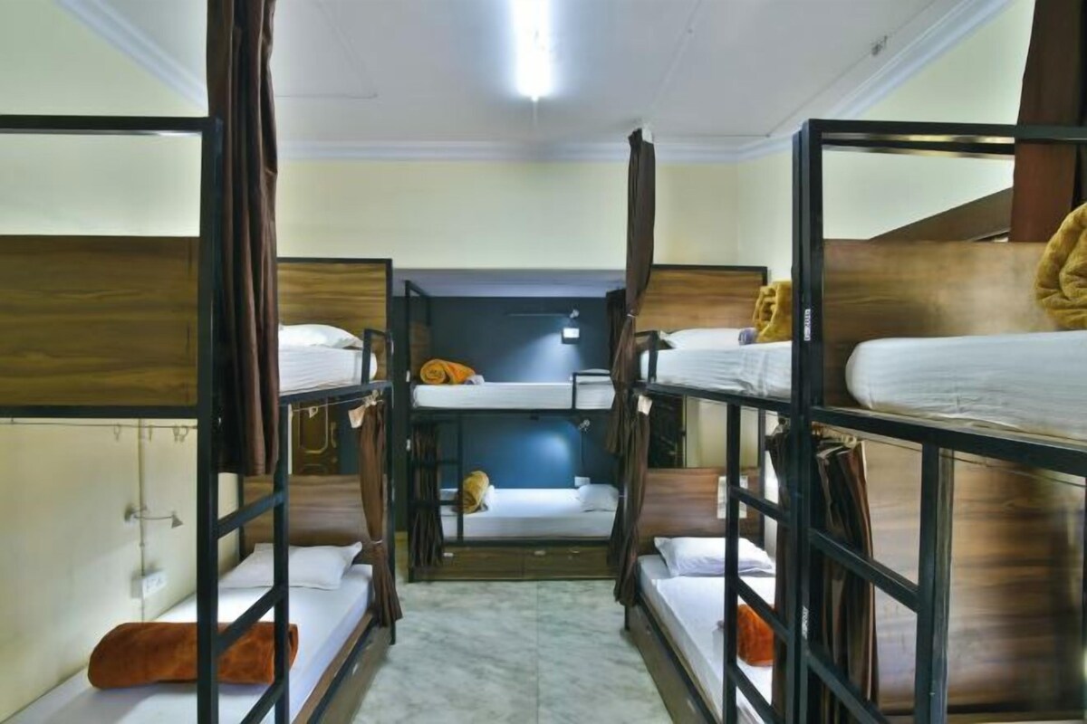 A bunk bed room with a central door, wooden walls, and a tiled floor.