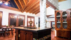 Un intérieur rustique avec des poutres apparentes, un comptoir carrelé et un buffet traditionnel.