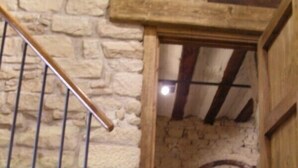 A rustic staircase with stone walls and wooden beams, leading to a lower level. - Casa Rural Fernandoegea (Ezprogui)