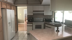 A kitchen with a refrigerator, stove, and sink. - 3 bedroom Pool home. Quiet Neighbourhood (Spring hill)