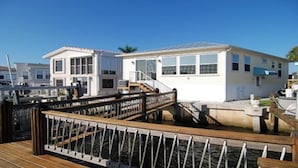 Uma propriedade à beira-mar com um deck de madeira e área coberta.