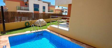 Alberca al aire libre y camastros