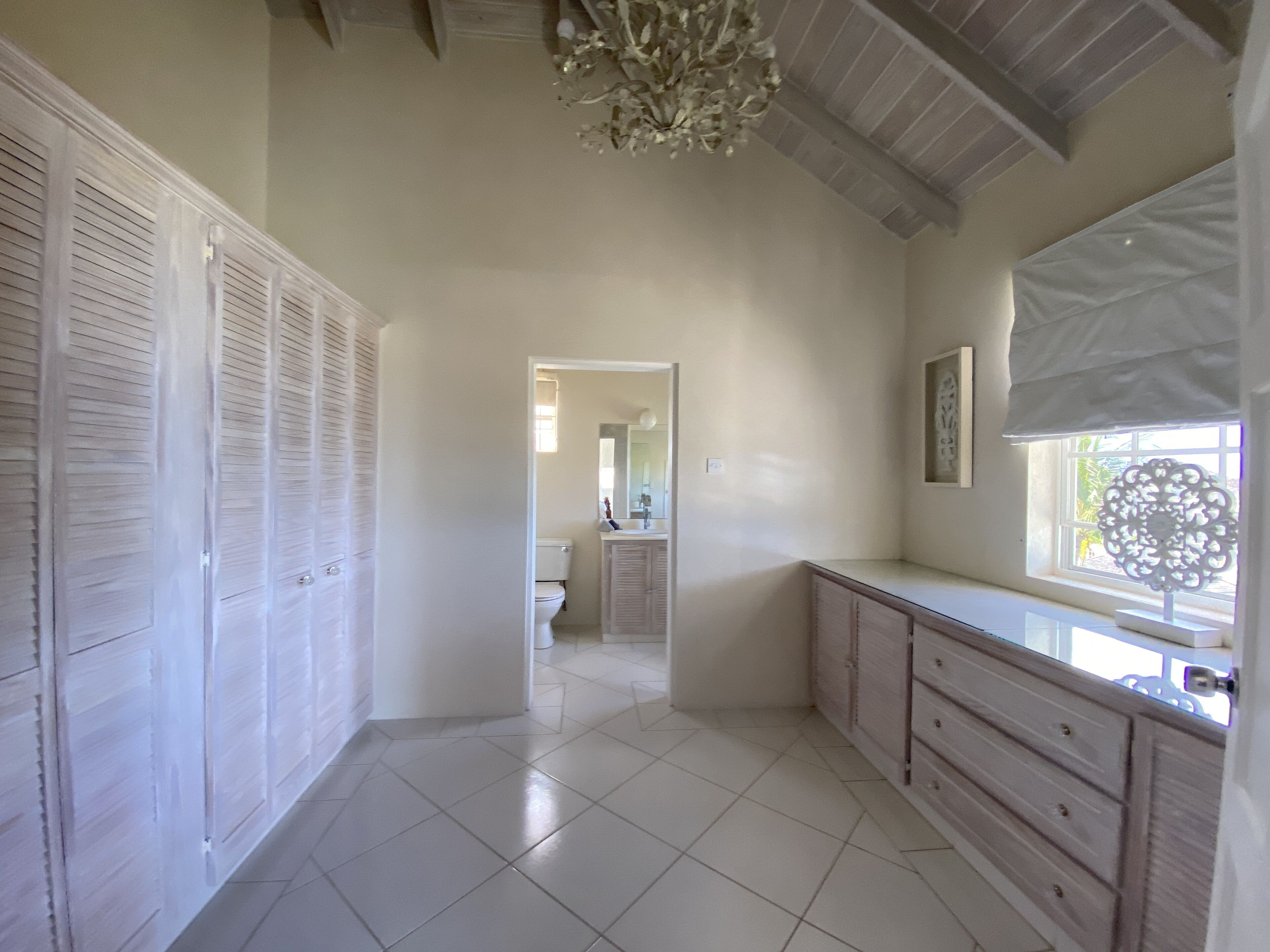 A spacious bathroom with a large vanity, a toilet, and a shower area.